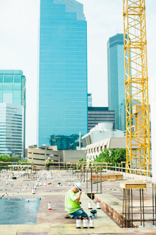 worker on the ground measuring for mixed-use development site in Minneapolis