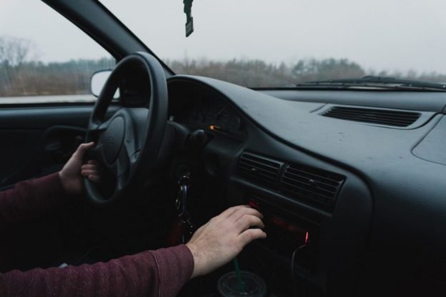 Driver changing radio station which is a type of distracted driving