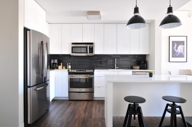 Multifamily housing apartment kitchen with white cabinets and wood floors