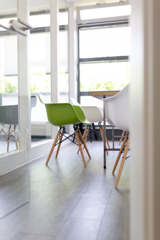 Green chair in conference room with windows and lots of natural light