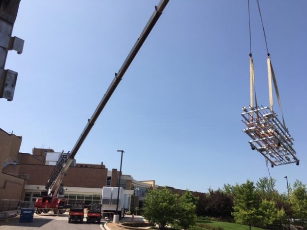 Crane hoisting HVAc prefab for healthcare facility